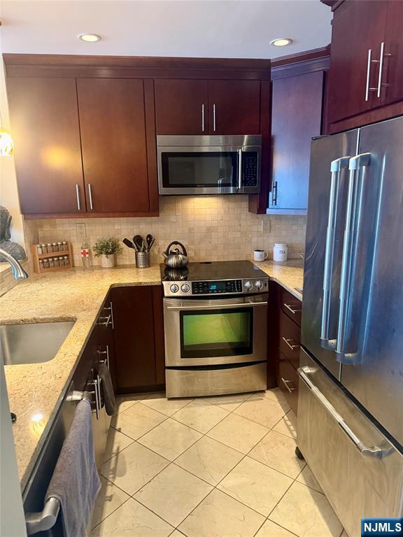 a kitchen with granite countertop a refrigerator stove and sink