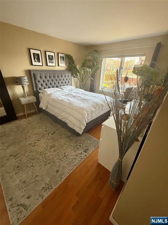 102 Nelson Court, Unit O102 Edgewater, NJ 07020 - Photo 6 of 15 a bedroom with a bed and a night stand