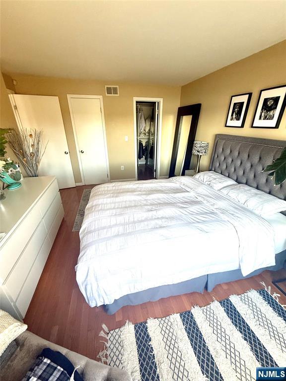 102 Nelson Court, Unit O102 Edgewater, NJ 07020 - Photo 8 of 15 a spacious bedroom with a bed and a mirror