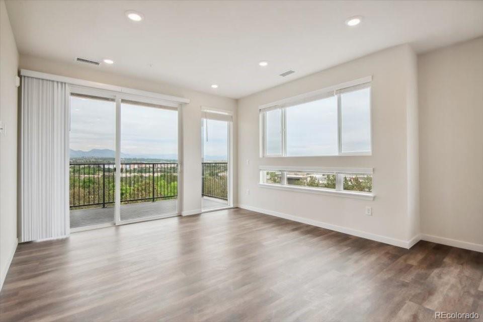 485 Interlocken Boulevard, Unit 305 Broomfield, CO 80021 - Photo 5 of 14 an empty room with wooden floor and windows