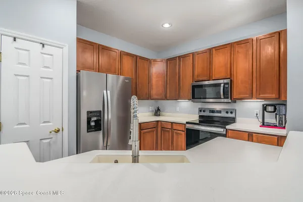 a kitchen with stainless steel appliances granite countertop a refrigerator stove and sink