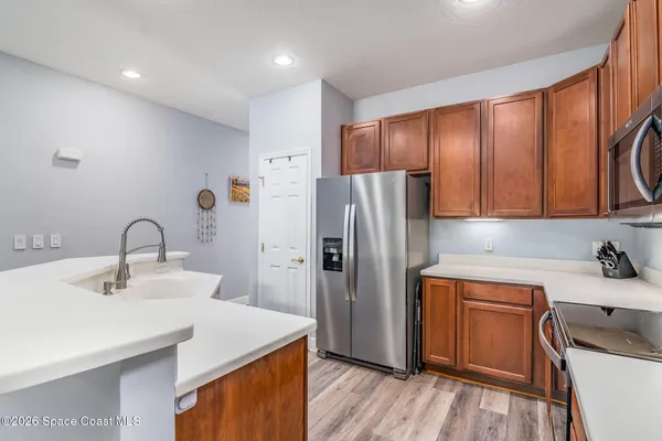 a kitchen with a sink a refrigerator and cabinets