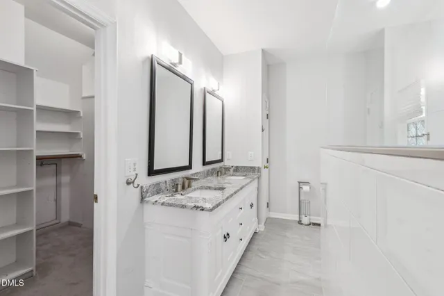 a spacious bathroom with a granite countertop sink and a mirror