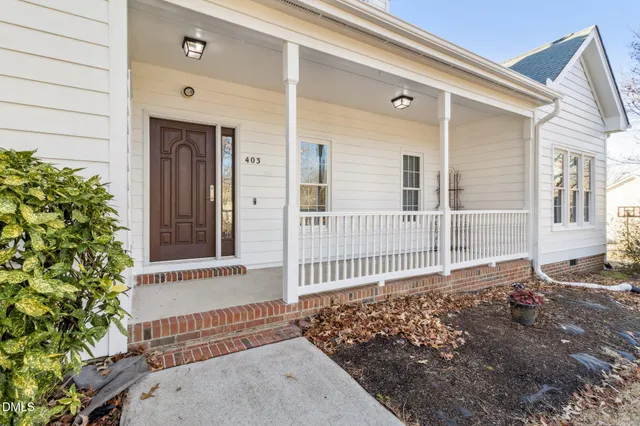 a view of a house with a small yard and wooden floor and fence