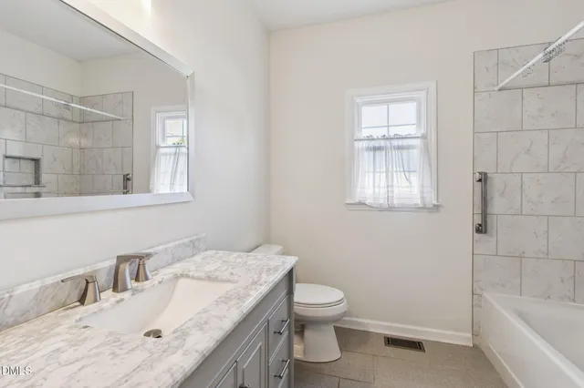 a bathroom with a sink toilet vanity and tub