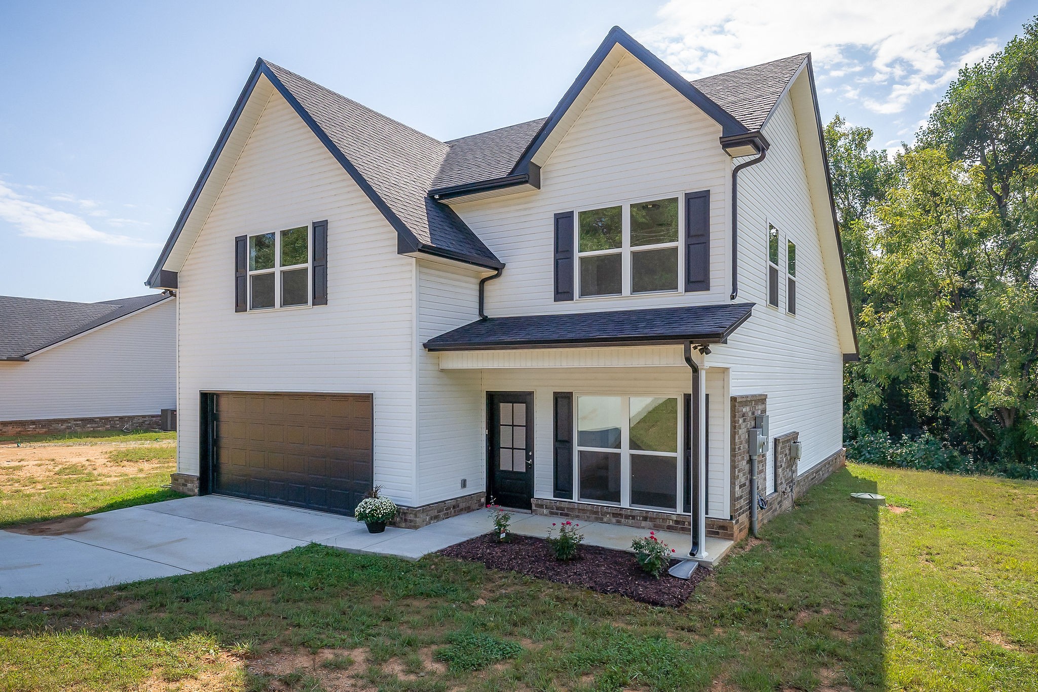a view of a house with a yard and large tree