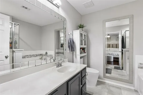 a bathroom with a sink a toilet a mirror and shower