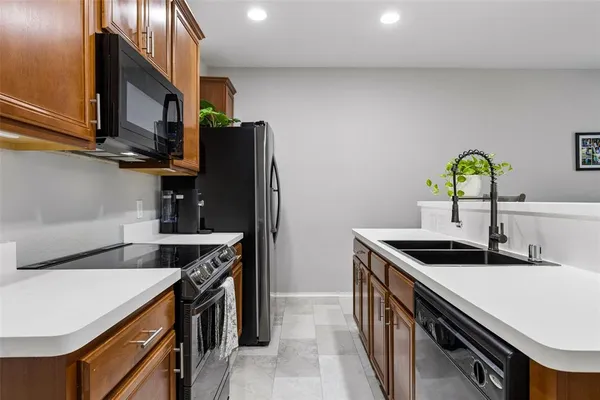 a kitchen with stainless steel appliances granite countertop a sink and a refrigerator