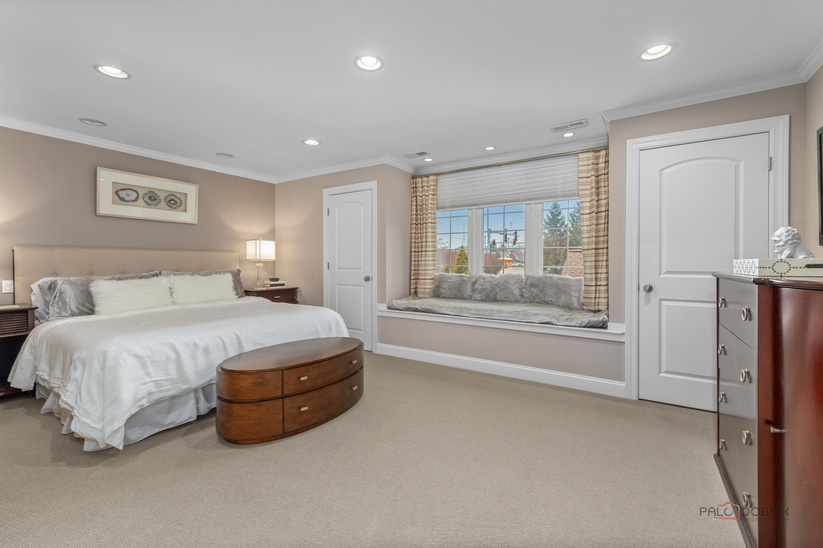 2 North Tower Road Oak Brook, IL 60523 - Photo 22 of 40 a spacious bedroom with a large bed and a chandelier