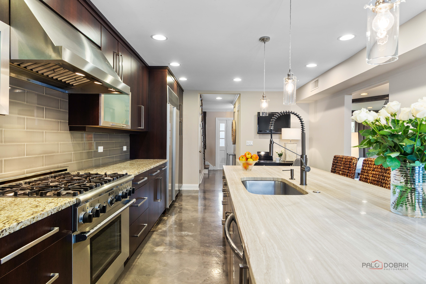 2 North Tower Road Oak Brook, IL 60523 - Photo 9 of 40 a large kitchen with stainless steel appliances a large counter top a stove and a sink with living room
