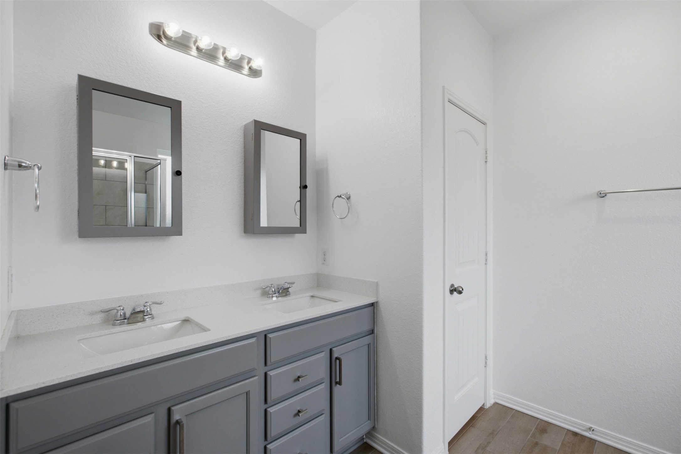 2413 Bridges Ranch Road Georgetown, TX 78628 - Photo 17 of 31 Double vanities with sleek gray cabinetry and stone counters provide functional elegance in this bathroom.