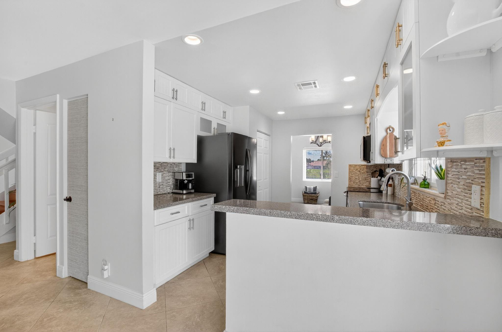 22271 Festival Way Boca Raton, FL 33428 - Photo 18 of 62 a kitchen with stainless steel appliances kitchen island granite countertop a refrigerator and a stove top oven