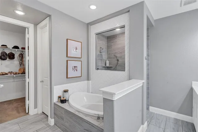 a bathroom with a tub sink and mirror