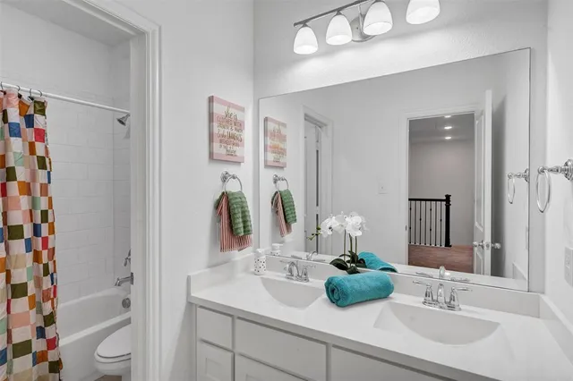 a bathroom with a sink a toilet and shower curtain