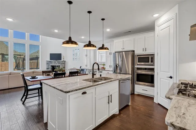 a kitchen with stainless steel appliances granite countertop a sink stove and refrigerator