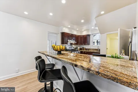 a kitchen with a table chairs refrigerator and microwave