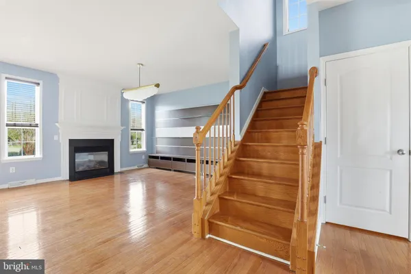 a view of a livingroom with wooden floor and stairs