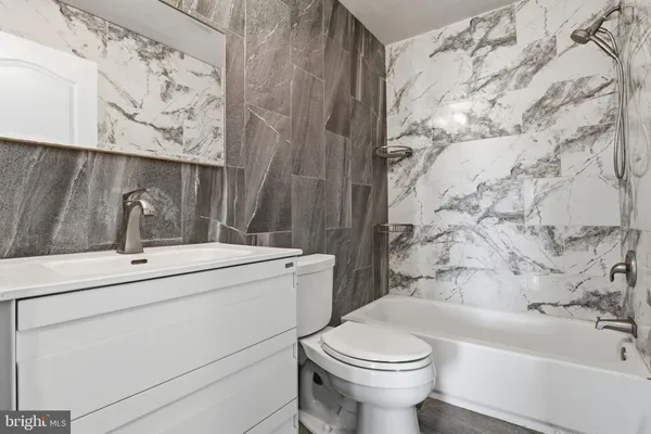 a bathroom with a sink and mirror with toilet
