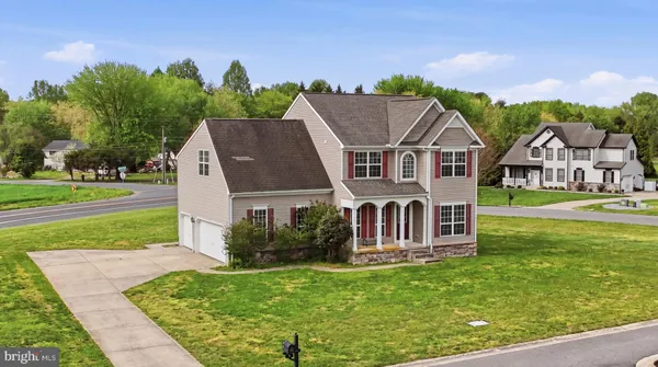 a view of a house with a big yard plants and large trees