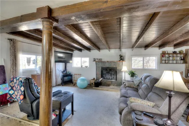 a living room with furniture large window and chandelier