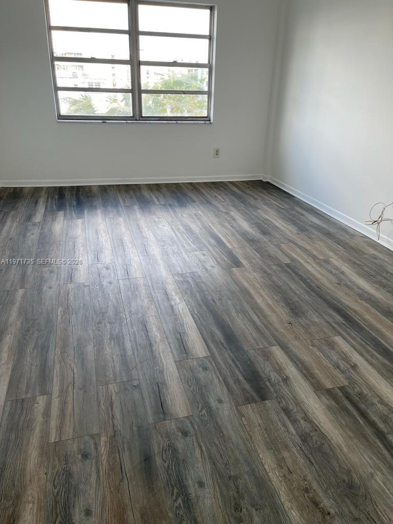 1450 Lincoln Road, Unit 604 Miami Beach, FL 33139 - Photo 12 of 16 an empty room with wooden floor and windows
