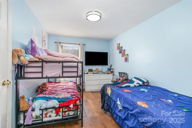 a bedroom with furniture and a flat screen tv