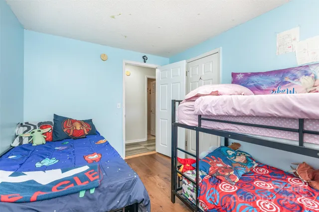 a bedroom with a bed that has a blanket on it and next to a couch