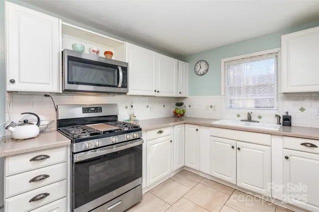 a kitchen with granite countertop white cabinets and white appliances