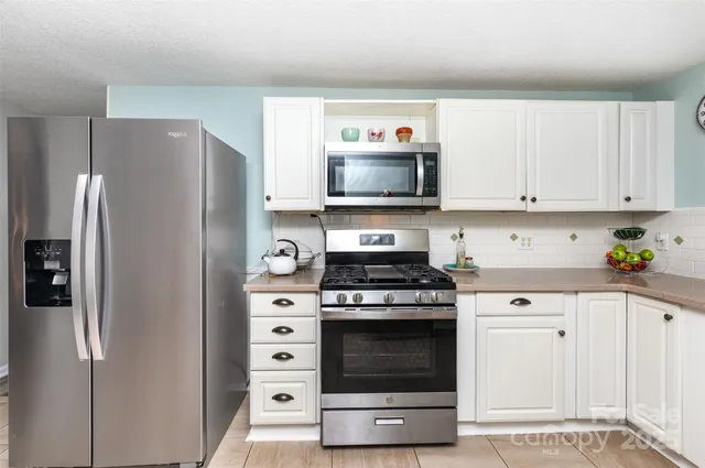 a kitchen with stainless steel appliances a stove a microwave and a refrigerator