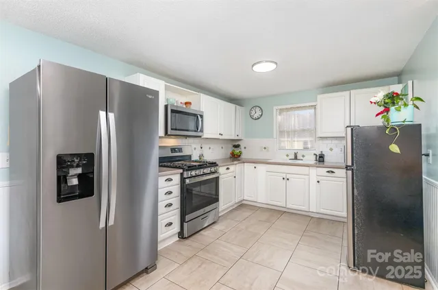 a kitchen with stainless steel appliances granite countertop a refrigerator sink and cabinets