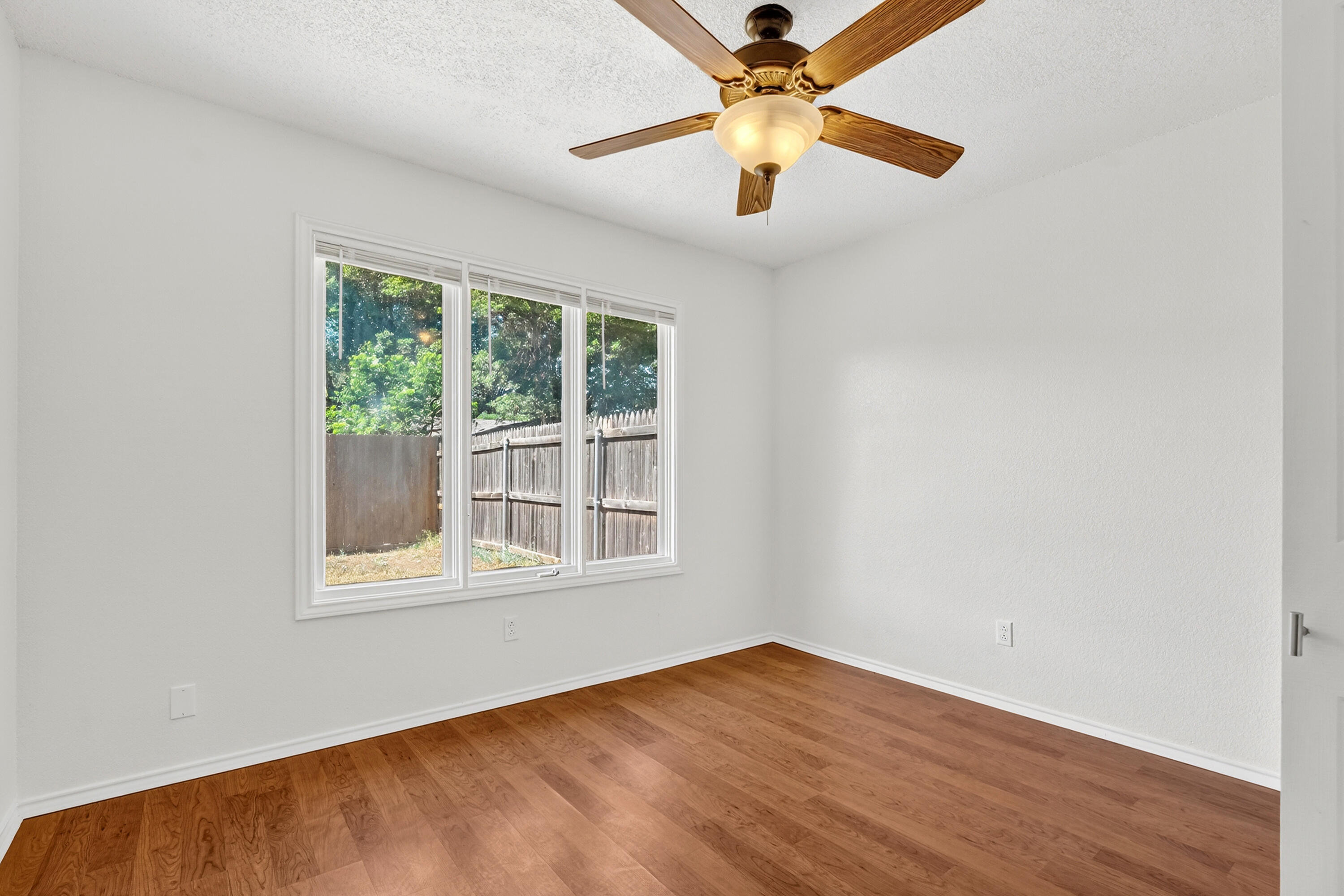 5221 84th Street Lubbock, TX 79424 - Photo 21 of 26 an empty room with wooden floor fan and windows
