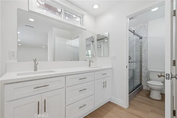 a bathroom with a double vanity sink toilet and shower