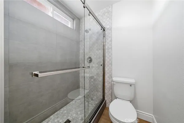 a bathroom with a granite countertop toilet a sink and shower