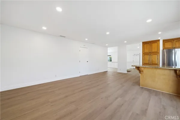 a view of a kitchen with wooden floor and a window