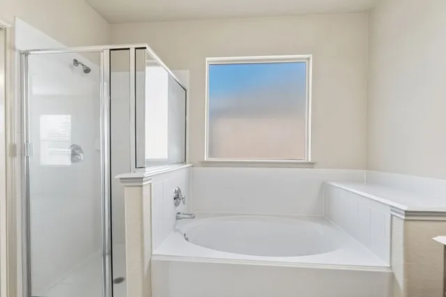a white bath tub sitting next to a white cabinet