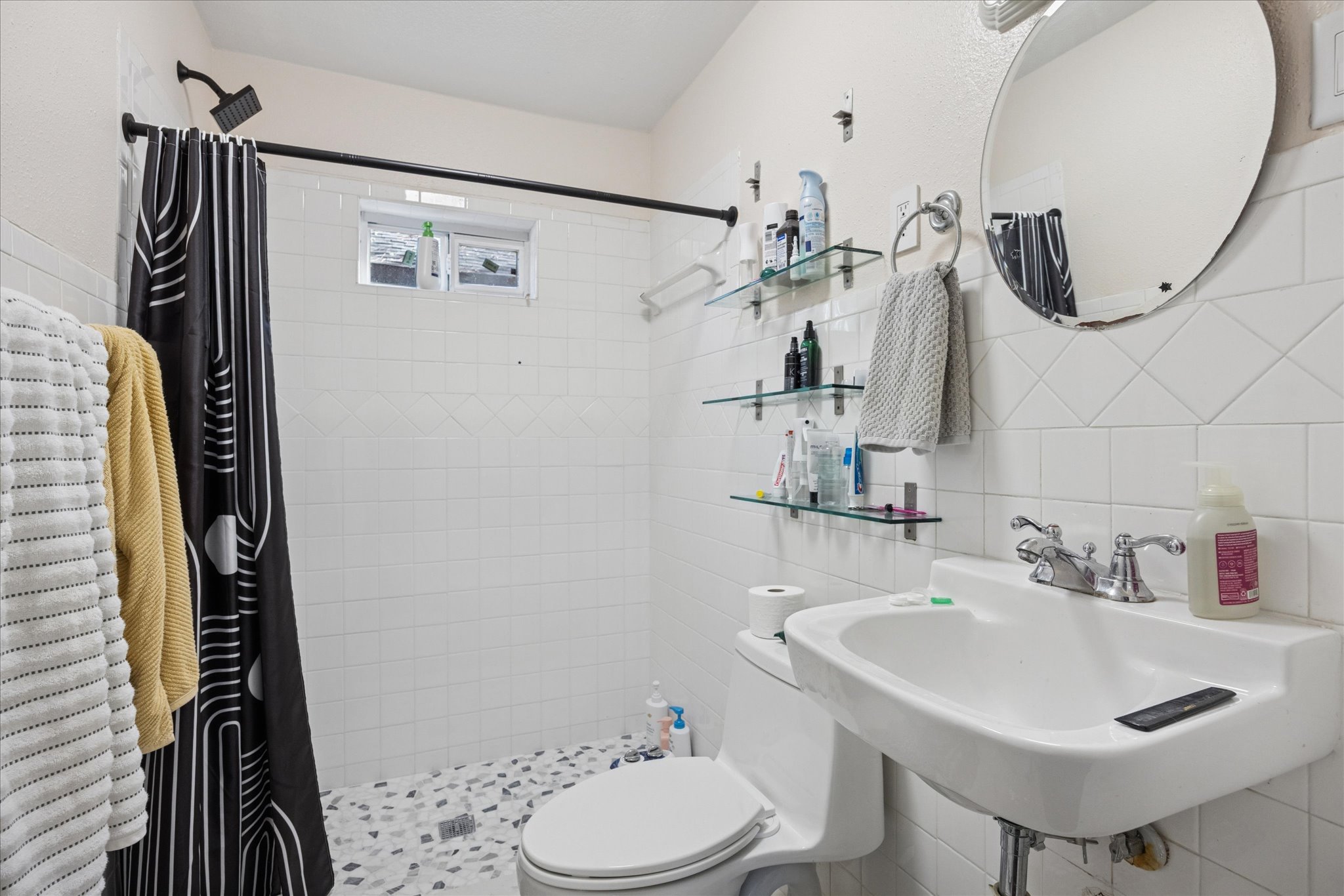 907 East 53rd Street Austin, TX 78751 - Photo 12 of 30 Bathroom featuring tile walls, decorative backsplash, and a stall shower