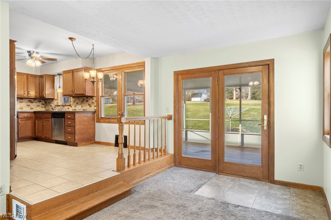 227 South Messner Road New Franklin, OH 44319 - Photo 18 of 44 Entryway with sink, light tile floors, a healthy amount of sunlight, and ceiling fan with notable chandelier