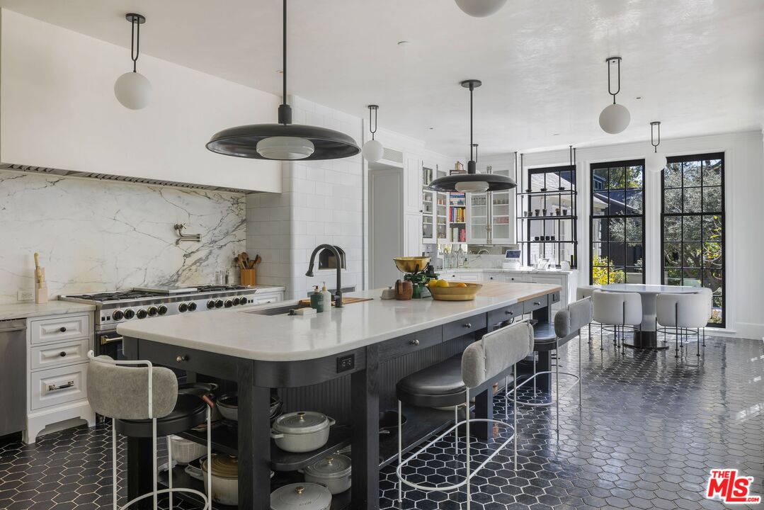 1701 Westridge Road Los Angeles, CA 90049 - Photo 14 of 36 a kitchen with stainless steel appliances granite countertop a table and chairs in it