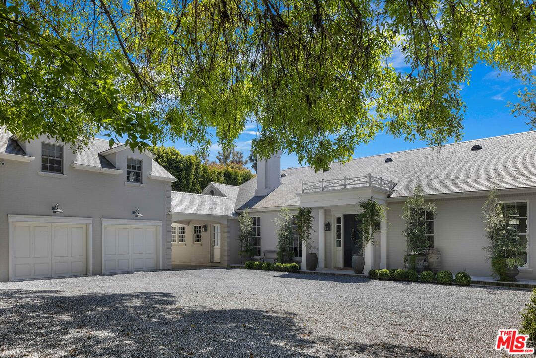 1701 Westridge Road Los Angeles, CA 90049 - Photo 2 of 36 a front view of a house with a garden