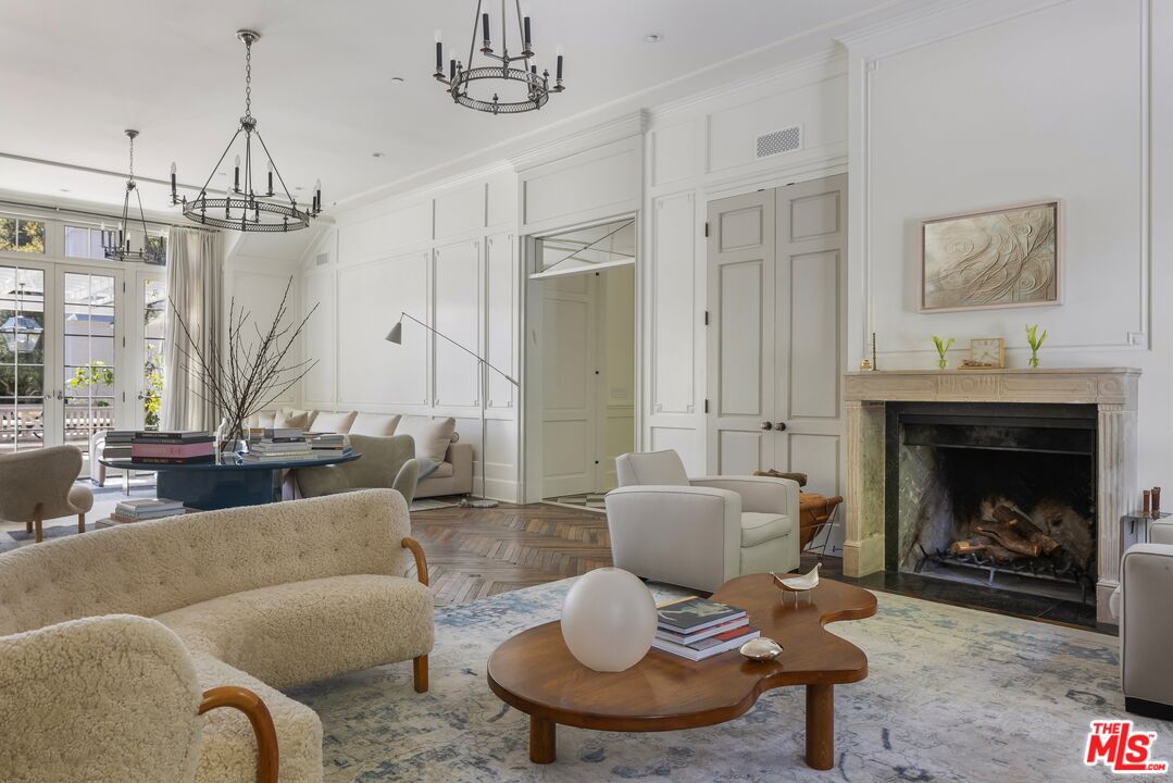 1701 Westridge Road Los Angeles, CA 90049 - Photo 6 of 36 a living room with furniture a chandelier and a fireplace