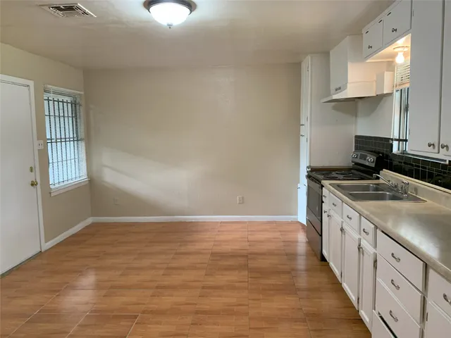 a kitchen with granite countertop a sink stove and cabinets