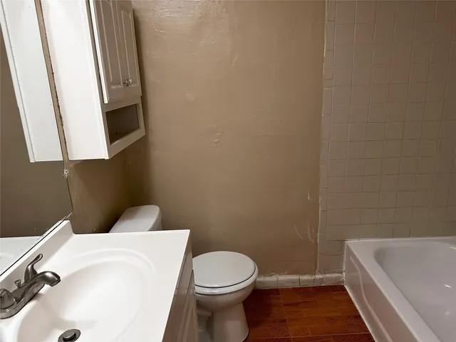 a white toilet sitting next to a white tub