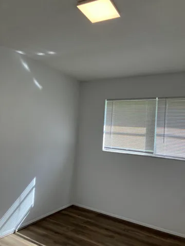 a view of a room with wooden floor and window