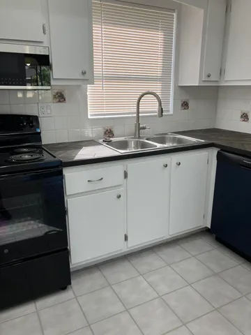 a kitchen with granite countertop white cabinets and a stove