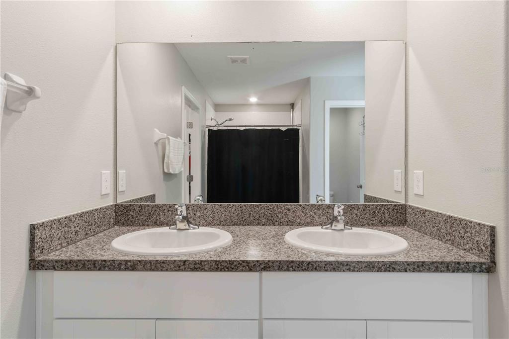 9440 Lemon Drop Loop Sun City Center, FL 33573 - Photo 36 of 55 a bathroom with a granite countertop sink and a mirror