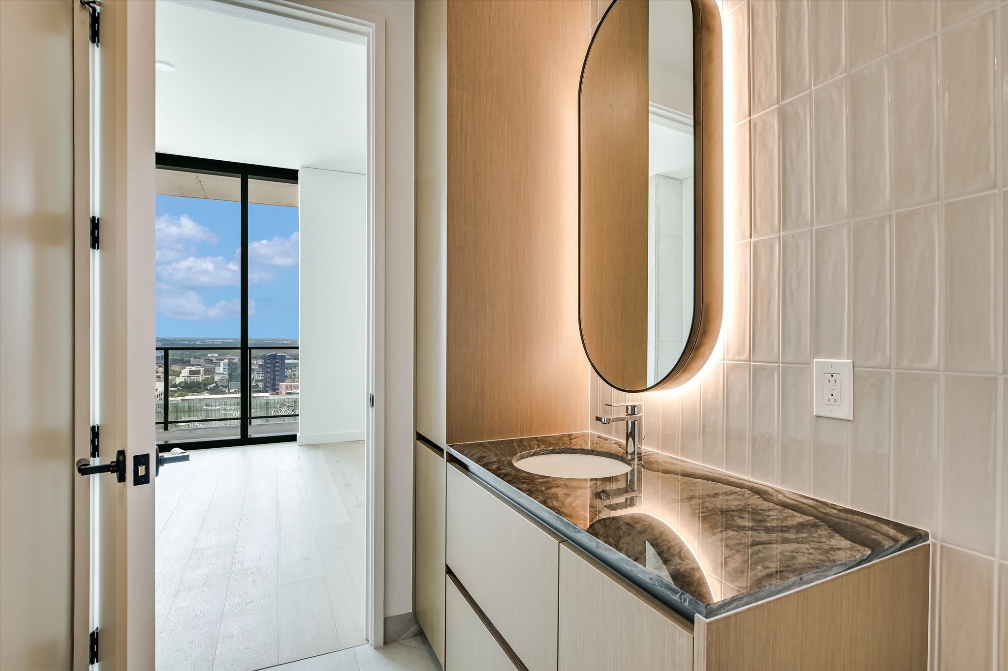 610 Davis Street, Unit 4704 Austin, TX 78701 - Photo 23 of 40 a bathroom with a granite countertop sink and a mirror