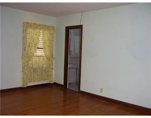 an empty room with wooden floor and closet