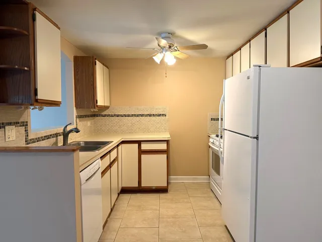 a kitchen with a refrigerator a sink and cabinets