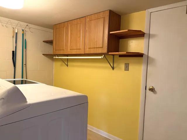 an empty room with a chandelier fan and windows