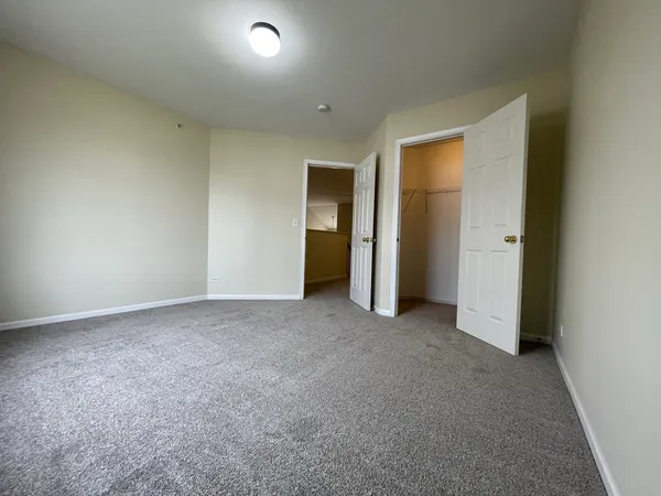 an empty room with closet and a window